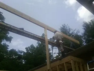 Carpenter setting a ridge beam over a new addition frame — Ice Dam Removal by Roofing Brothers in Mc Knightstown