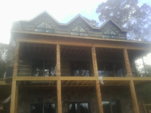 Dormers and porch framing on a large log home under construction — Roof Coating work by our crew in Mc Knightstown