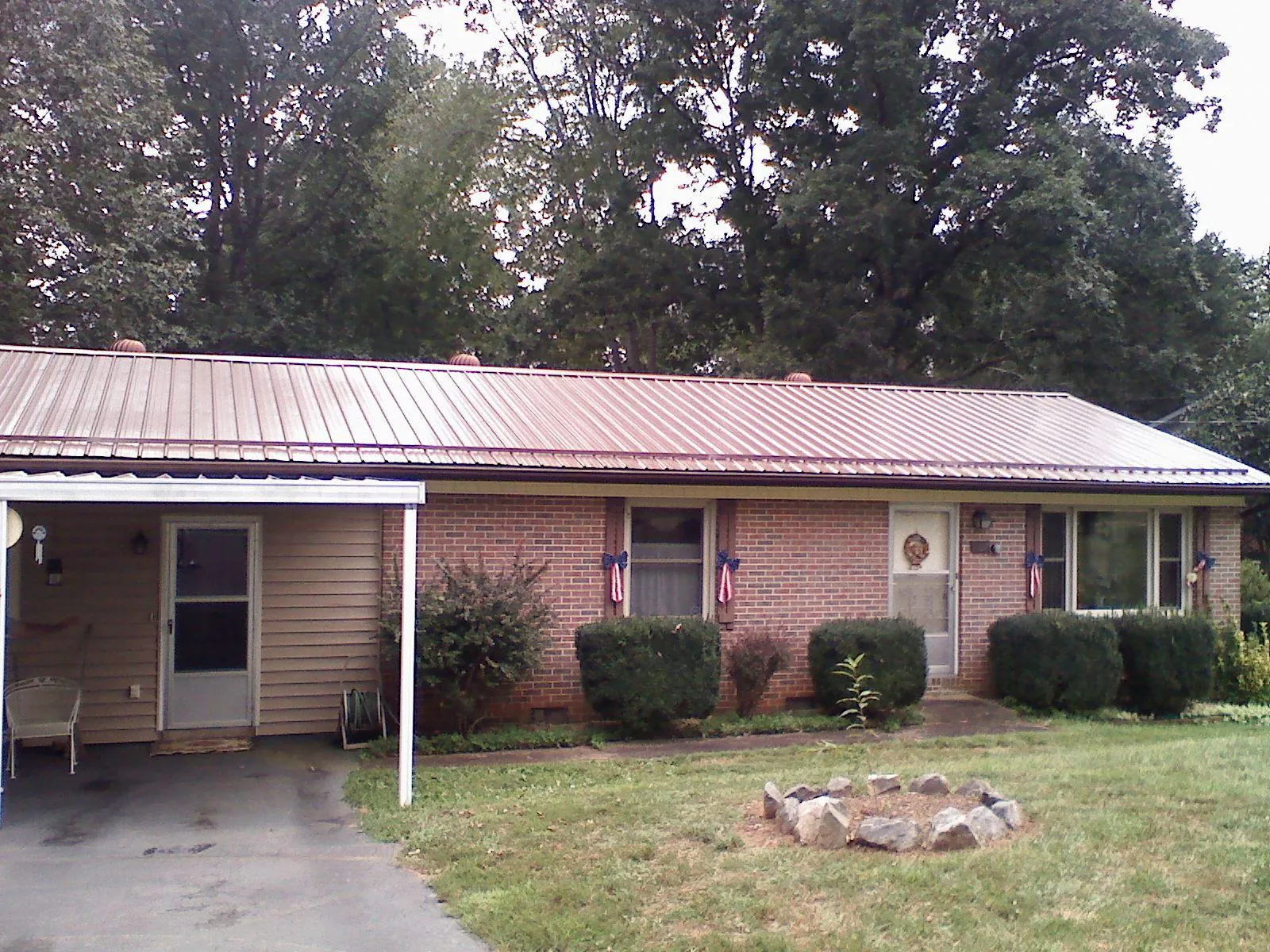 Bronze metal roof and carport on a brick ranch home — Roof Repair work by our crew in Mc Knightstown